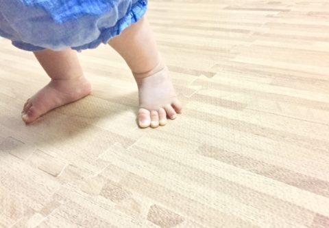 つかまり立ちをして踏ん張っている赤ちゃんの足