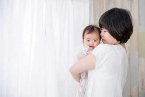 ママに抱っこをされる赤ちゃん